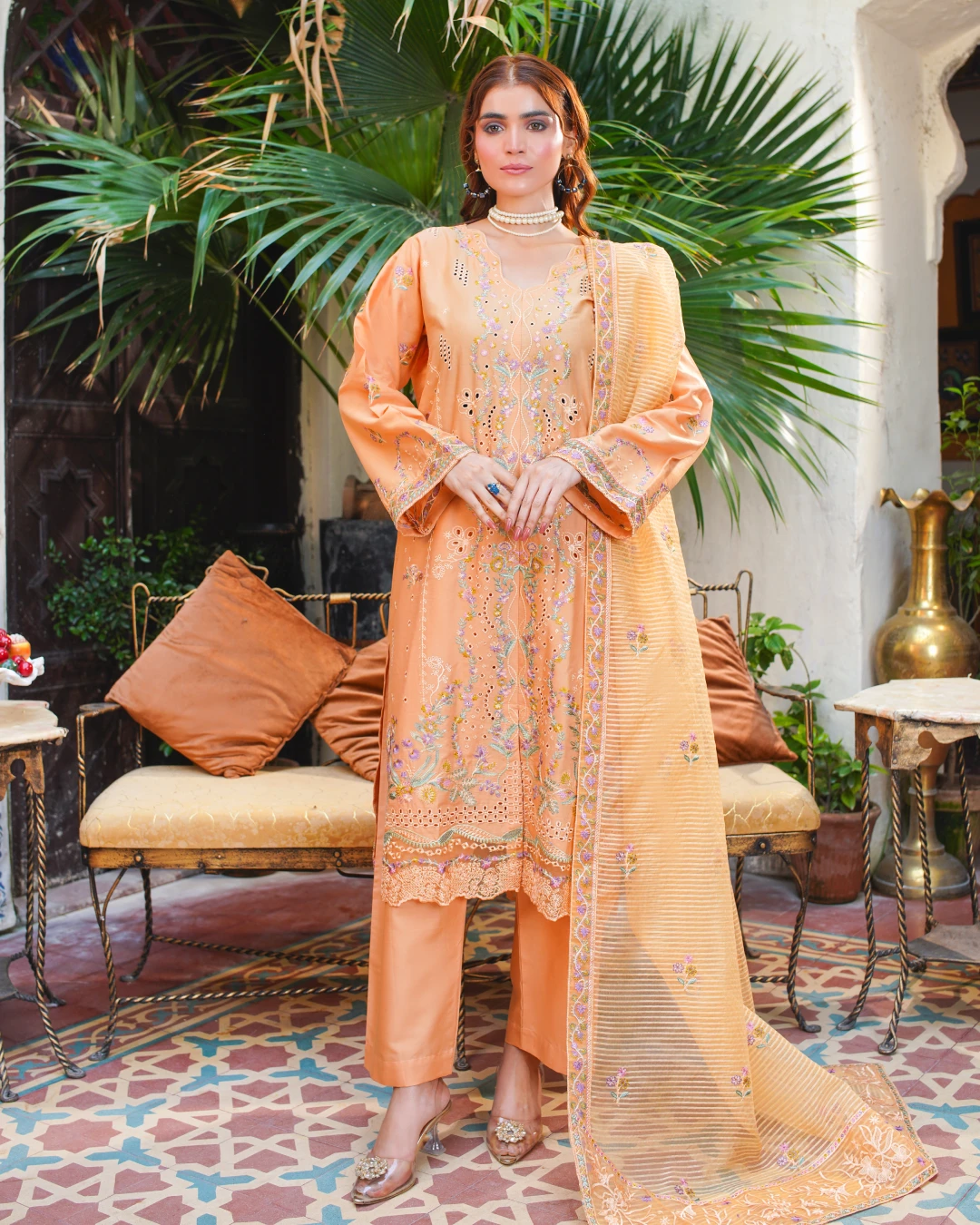 Step into soft sophistication with this Aatiqa.com peach lawn suit. This 3-piece unstitched ensemble features intricate multi-colored floral embroidery and beautiful cutwork detailing on the shirt. The lightweight, breathable lawn fabric is perfect for spring and summer.