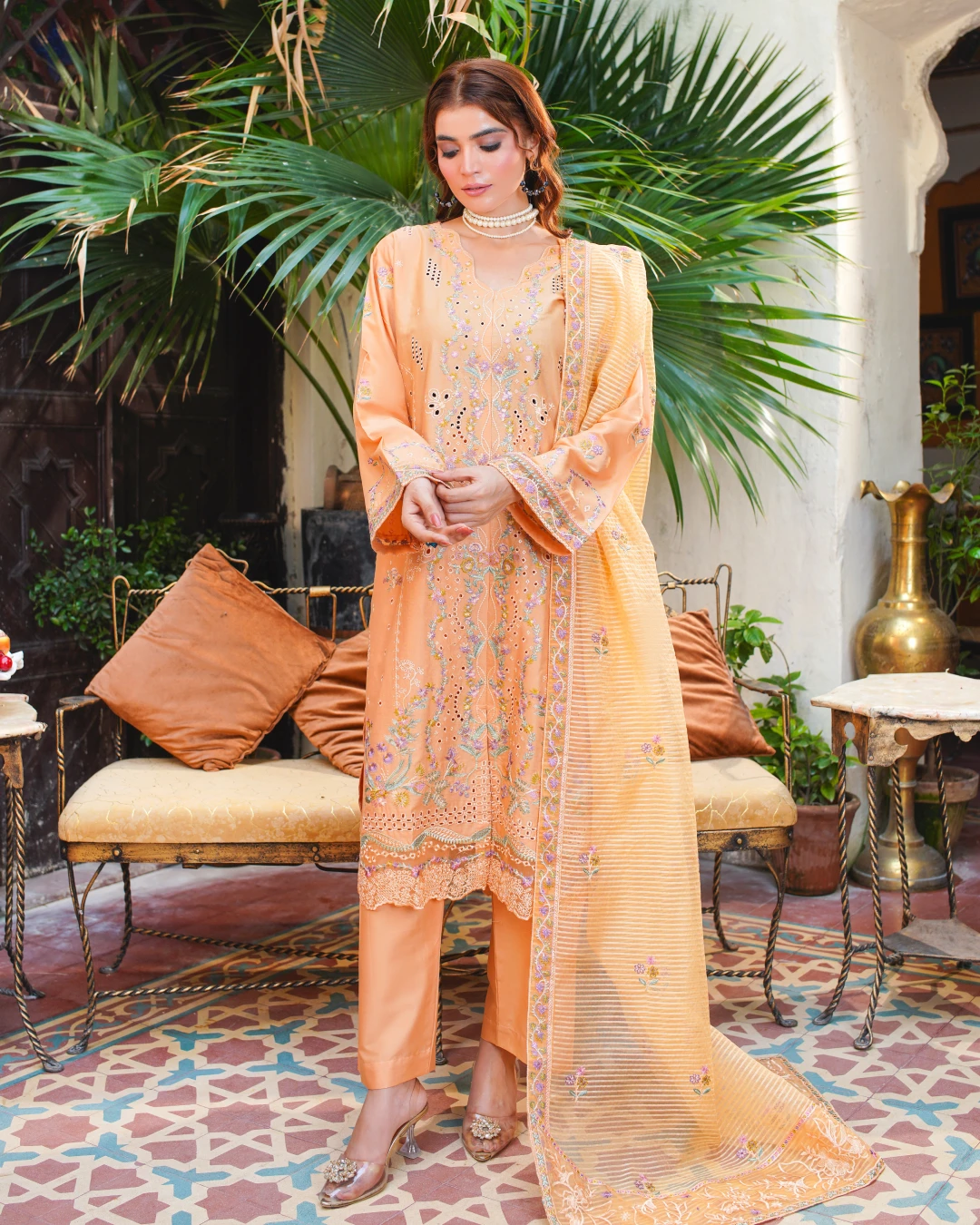 Step into soft sophistication with this Aatiqa.com peach lawn suit. This 3-piece unstitched ensemble features intricate multi-colored floral embroidery and beautiful cutwork detailing on the shirt. The lightweight, breathable lawn fabric is perfect for spring and summer.